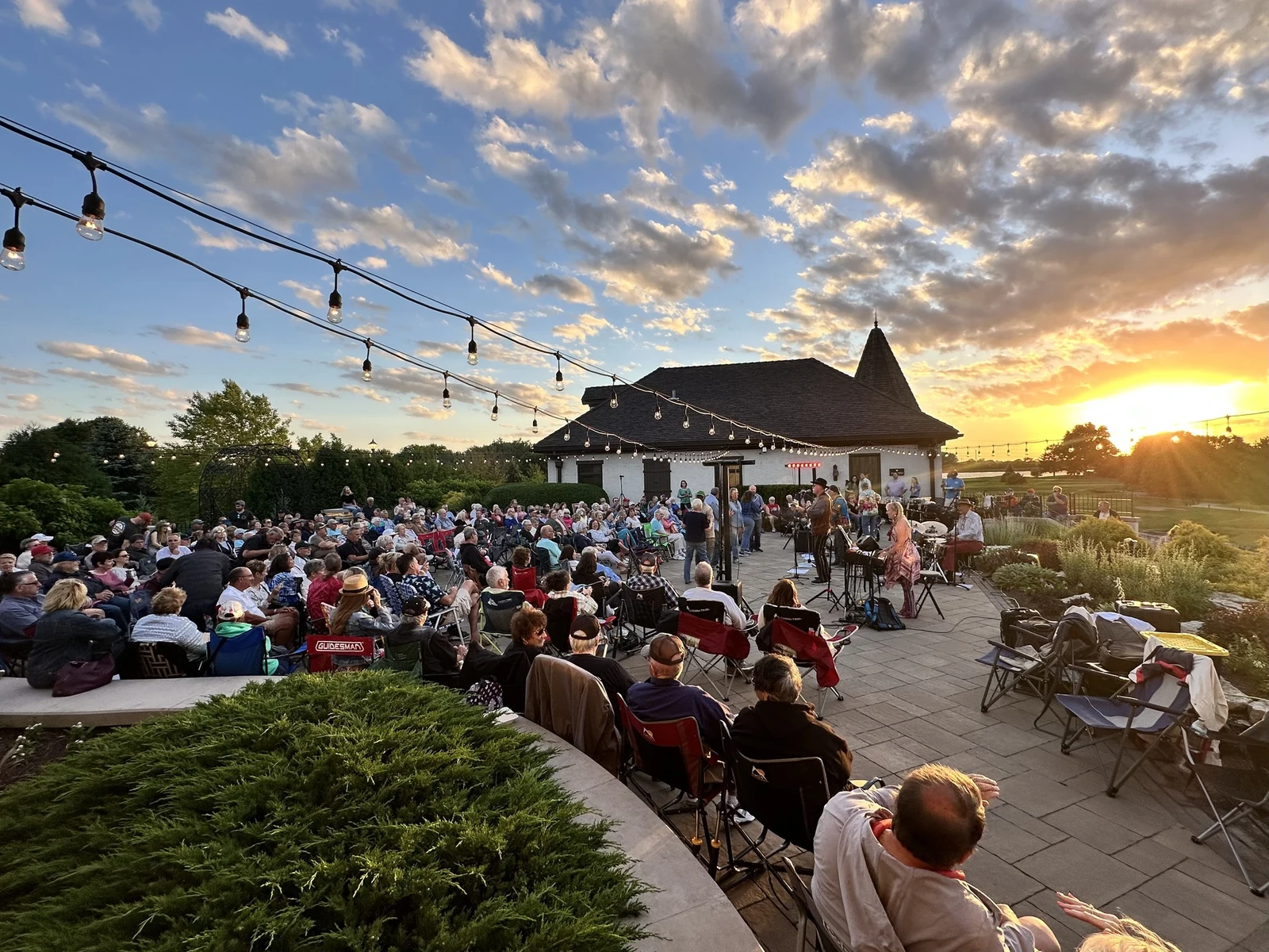 Hospitality event photography of outdoor live music crowd at sunset