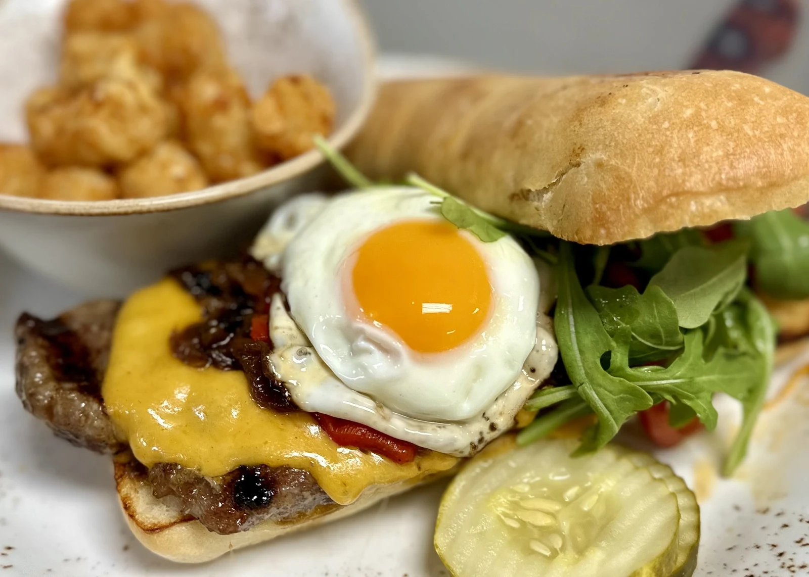 Restaurant food photography of fried-egg cheeseburger with greens