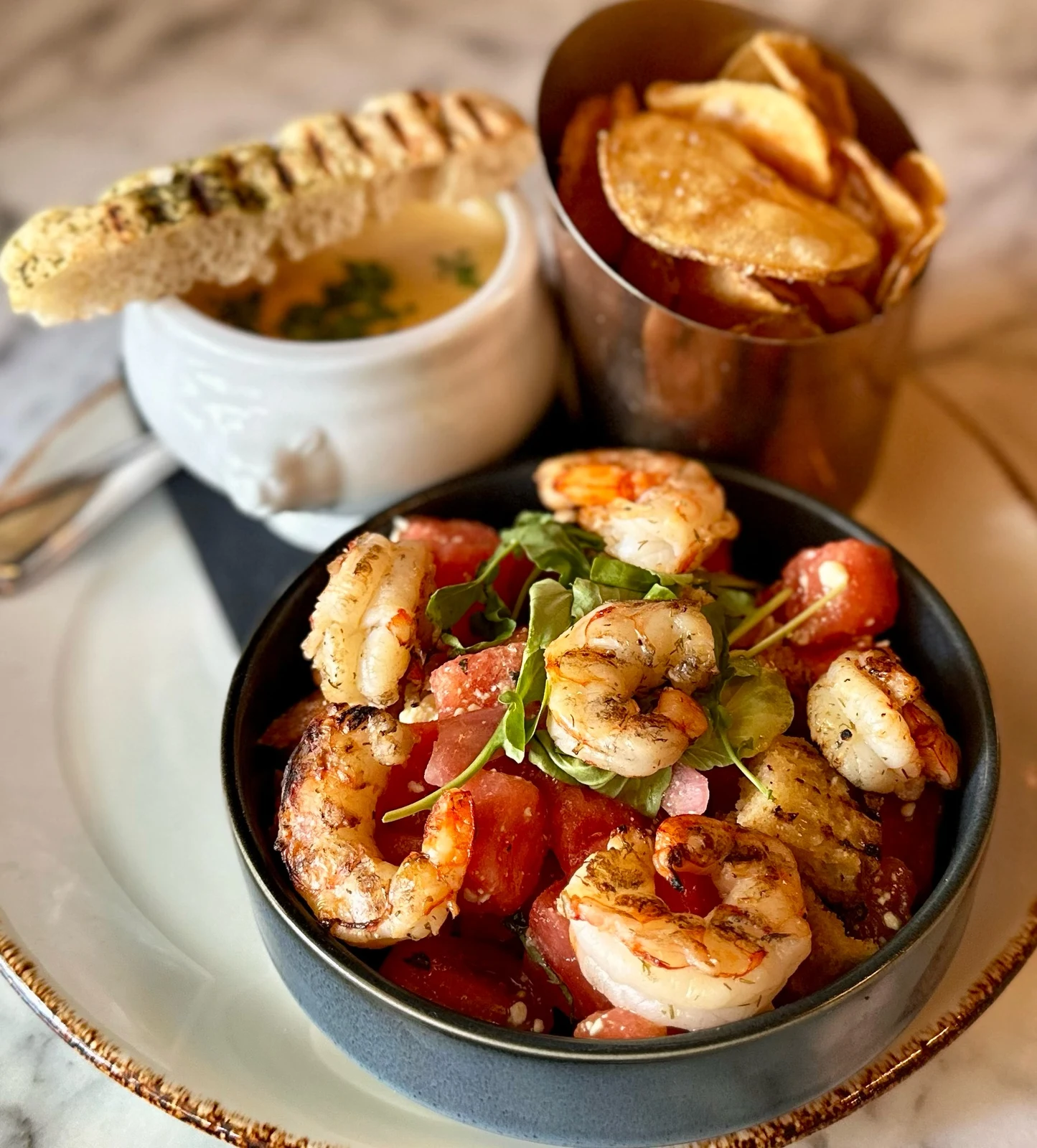 Restaurant food photography of grilled shrimp meal served with soup and accompanying sides